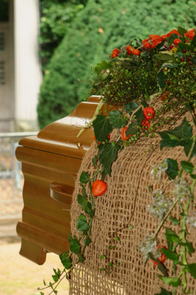 Sarg mit Blumen darauf